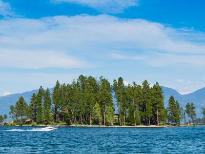 A boat drives by an island on the waters of Flathead Lake.