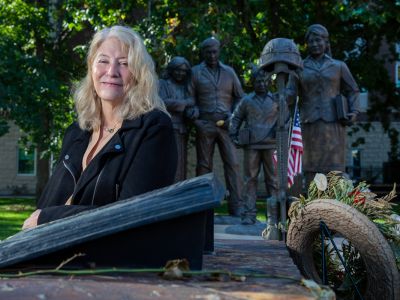 Photo of Cindi Laukes in front of veterans statue