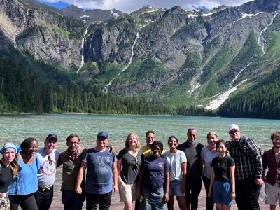 Scholars pose beneath waterfalls at Glacier National Park.
