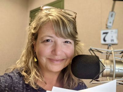 A picture of Jule Banville at a microphone.