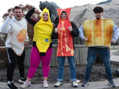 Students leaders dressed as food pose near the Grizzly Bear statue on campus.