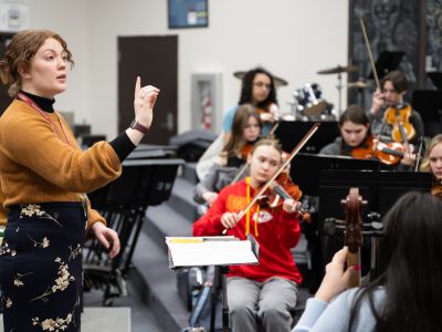 An image of UM student Marian Kale instructing a high school music classroom. 