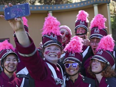 An image of UM marching band members taking a selfie together. 