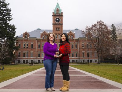 UM faculty members Anisa Goforth (left) and Jingjing Sun hold the 2024 Public Impact Research Award.