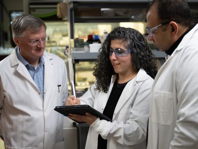 Jay Evans, Asia Riel and Walid Abdelwahab work in a lab.