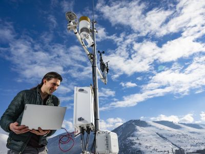 A photo of UM junior Joseph Knudsen standing on top of the Missoula Public Library with the HART Station. 