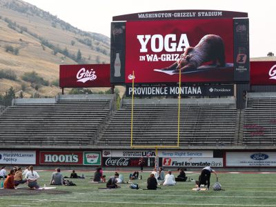 An image of people doing yoga in Washington-Grizzly Stadium. 