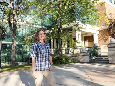 A picture of Brandi Ashford standing before the Gallagher Business Building.