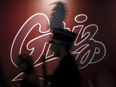 An image of a member of the Grizzly Marching Band walking by a Griz sign. 