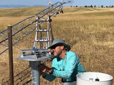 An individual installs a precipitation gauge.