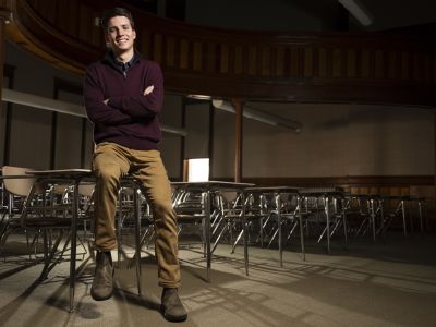ؿ student Buddy Wilson poses for a photo in an empty classroom.