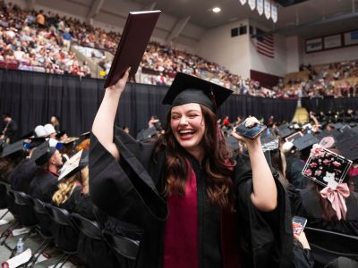 A UM graduate celebrates after receiving her diploma.