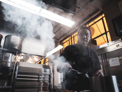 A photo of Sean Sherman cooking in a professional kitchen. 