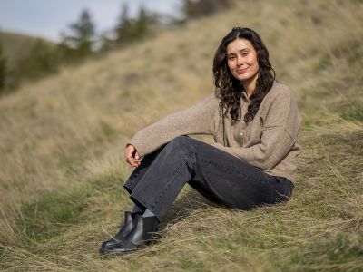 A picture of Emily Harman sitting on a mountain slope.