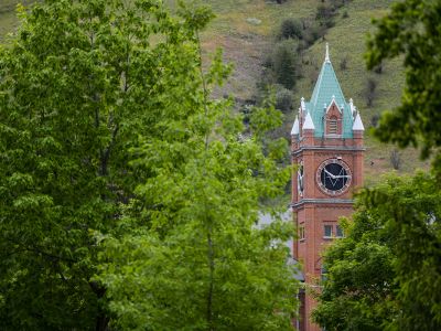 The Main Hall clock tower is visible between green trees.