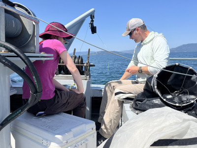 People sample water from a boat on Flathead Lake.