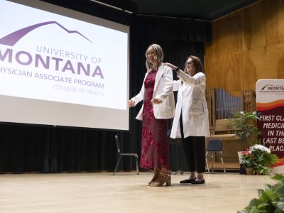 A UM student receives her white lab coat from PA program director Marci Contreras during a white coat ceremon