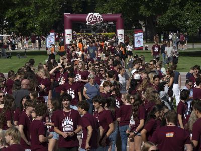 A crowd of students, and some of their parents, enjoy the Big Sky Experience on the Oval at UM.
