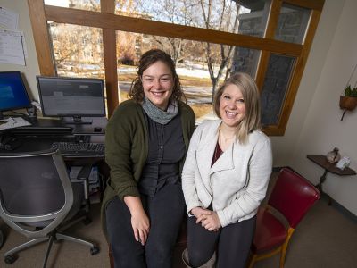 Two female staff members sit in a UM office.