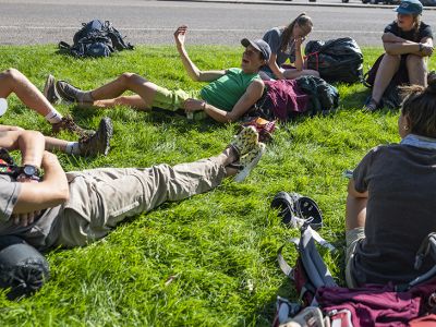 UM students sit on a green law on campus in a circle and talk