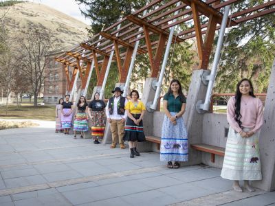 Student members of Kyiyo lean against the Payne Family Native American Center 