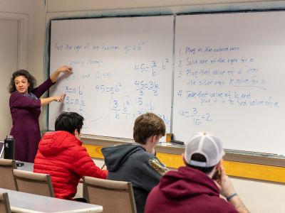 A woman teaches a math class 