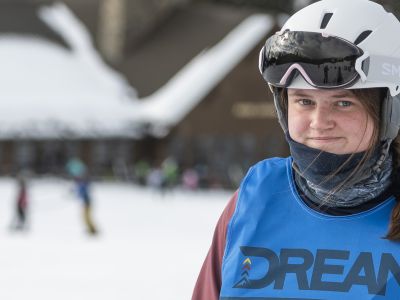 A woman in a ski helmet and a blue vest 
