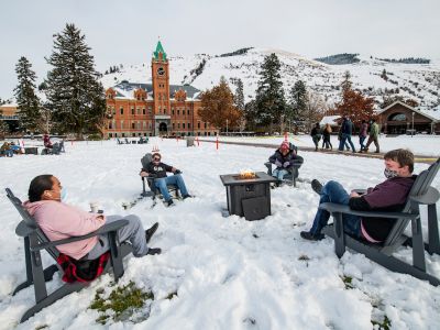 UM students sit around a firepit on the UM campus. 