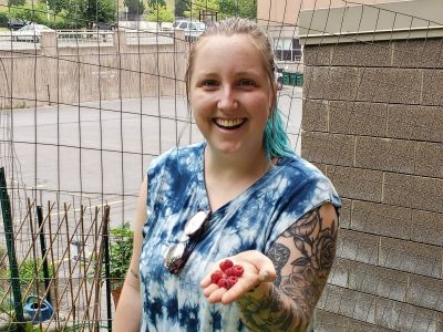 Student gardener shows off some fresh picked raspberries