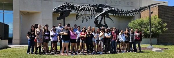 a group of students pose for a photo in front of a museum