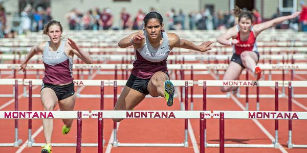 Student athlete jumping hurdles