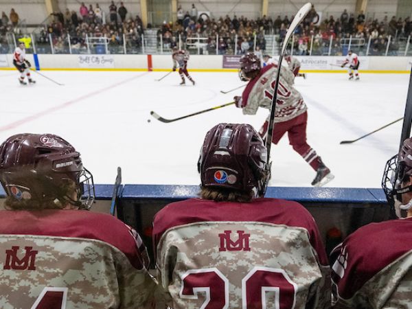 UM club hockey players line the bench at a game
