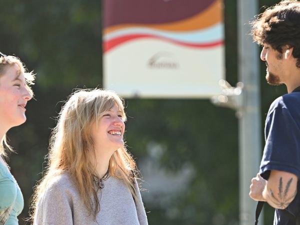Three students converse on the first day of fall semester at UM