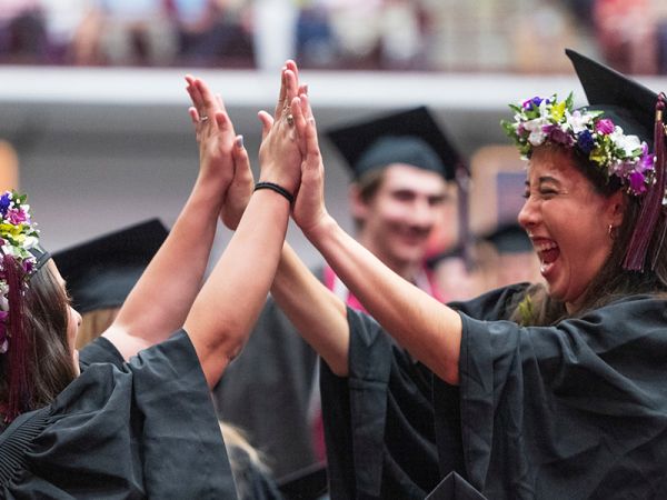 Two students celebrate at Commencement