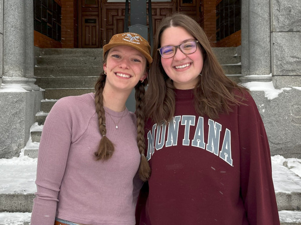 Two students standing next to each other in front of University Hall