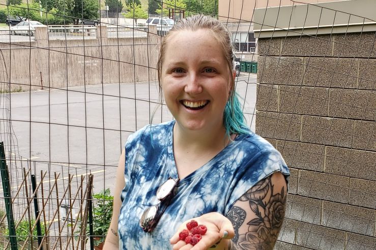 Student gardener shows off some fresh picked raspberries