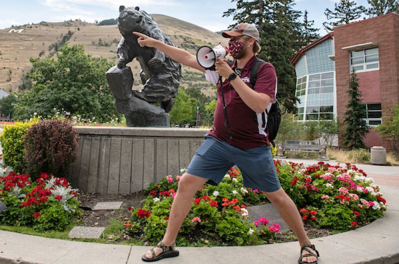 Bridger talks into a megaphone and points
