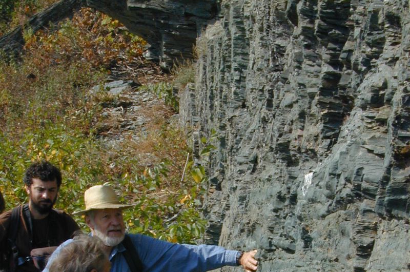 Don touches a rock face while three others look on