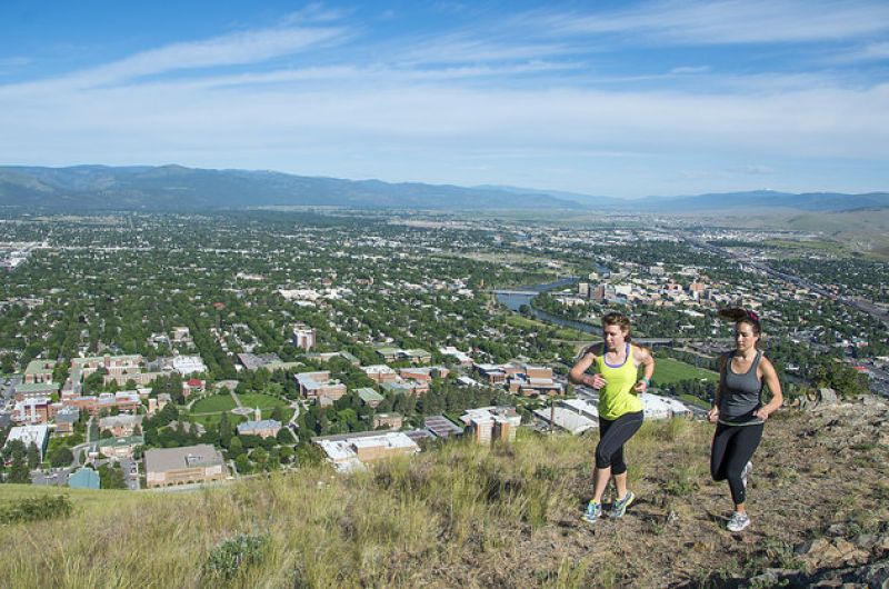 two women running on trail above missoula