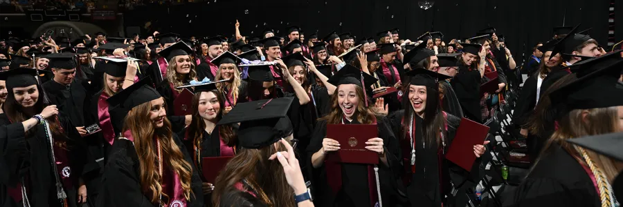 Graduates hold their diplomas during a Commencement ceremony